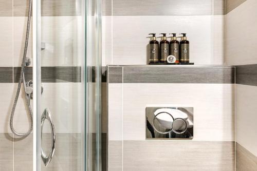 ein Badezimmer mit Dusche und Seifenspender in der Unterkunft Executive Hotel Evolution - Spiaggia Inclusa in Cesenatico