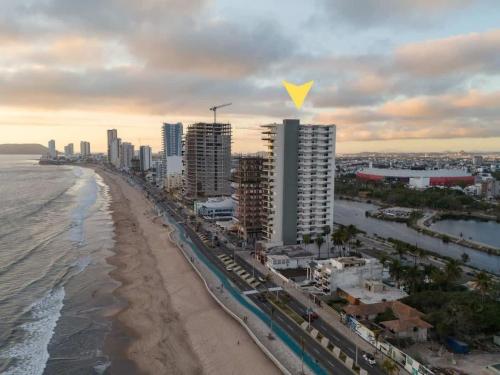 an aerial view of a beach with buildings and the ocean at On the Malecón with ocean lagoon & pool in Mazatlán