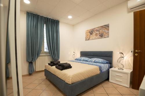 a bedroom with a bed with blue curtains at Mary s House Cerveteri Wifi AC in Cerveteri