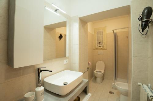 a white bathroom with a sink and a toilet at Mary s House Cerveteri Wifi AC in Cerveteri