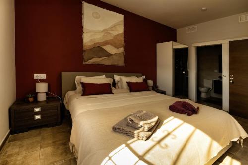 a bedroom with a large bed with a towel on it at Finca Tres Molinos B&B in Roldán