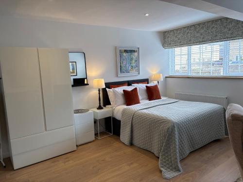 a white bedroom with a bed and a window at Yew Tree House in Woodstock