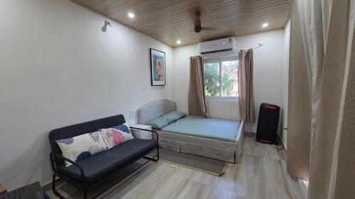 a living room with a couch and a window at Rewind by NestoraHomes in Jadgenhalli