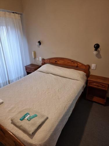 ein Schlafzimmer mit einem Bett, auf dem zwei Hausschuhe liegen in der Unterkunft Bahia Ourense Hotel in San Clemente del Tuyú