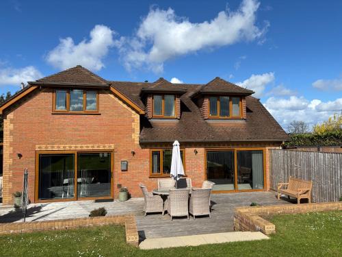 a house with a patio with a table and chairs at Countryside family home in Longwell Green