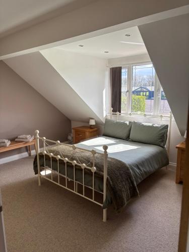 a bedroom with a bed and a window at Countryside family home in Longwell Green