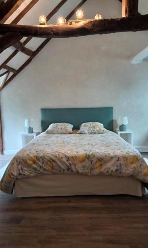 a bedroom with a large bed with a floral bedspread at Bed and Breakfast en Sarthe in Avoise