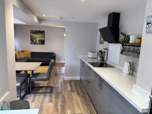 a kitchen and living room with a table and a couch at Homely house, foot of Snowdonia with private parking in Llanberis