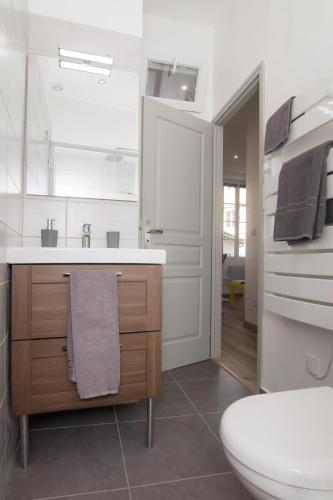 une salle de bain blanche avec un lavabo et des toilettes dans l'établissement LE PALAIS DES PAPES - AVIGNONSMILE, à Avignon
