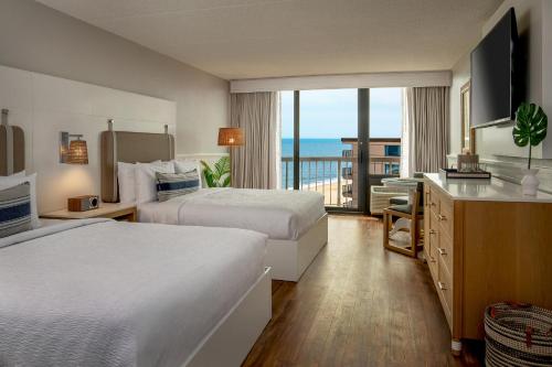 a hotel room with two beds and a balcony at Ashore Oceanfront Hotel by Marriott in Ocean City
