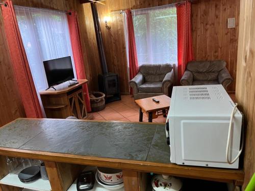 ein Wohnzimmer mit Fernseher und Mikrowelle in der Unterkunft cabañas arca in Pucón