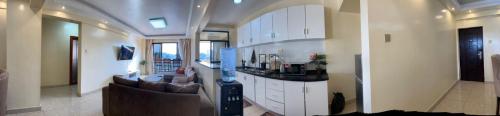 a living room with a couch and a kitchen at Kaisa Gardens in Nairobi