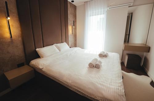 a bedroom with a bed with two towels on it at A-Apartment in Gjakove