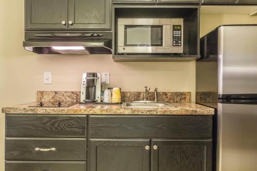 a kitchen with a sink and a microwave at Quality Inn & Suites in Moose Jaw