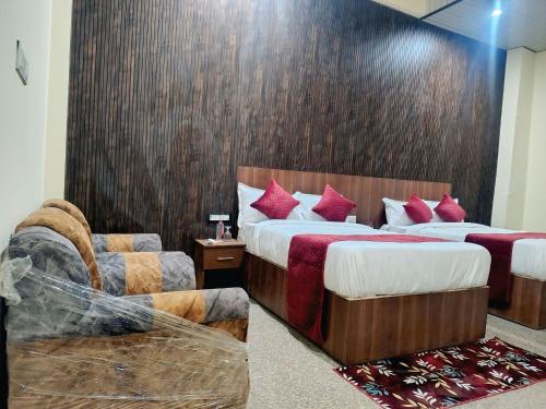 a hotel room with two beds and a couch at Hotel Udaan Stay in Jaipur