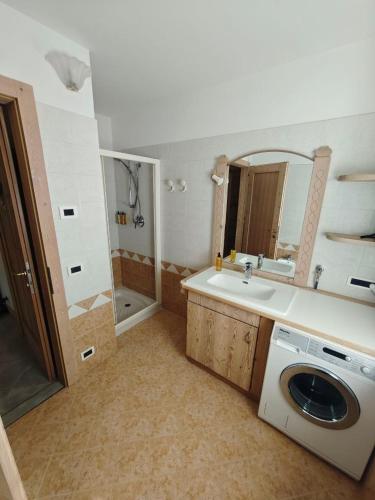 a bathroom with a sink and a washing machine at MB Appartamento in Santo Stefano di Cadore