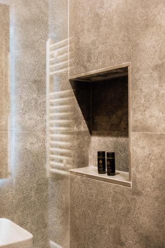 two candles sitting on a shelf in a bathroom at Dreamer's Luxury Suites in Volos
