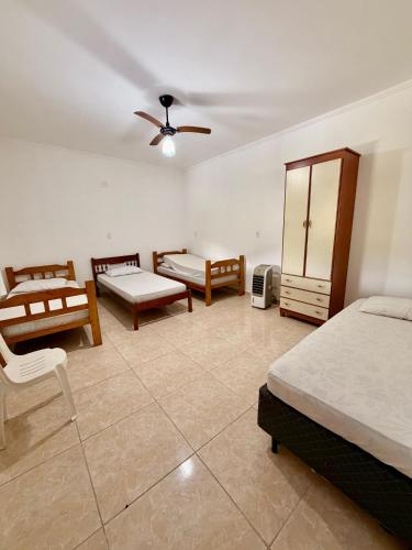 a bedroom with two beds and a ceiling fan at Chacara Souza in Socorro