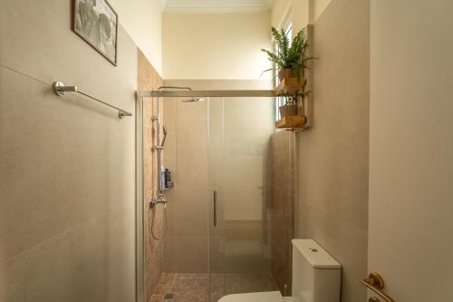 a bathroom with a shower and a toilet with a glass door at AROI Studio in Patra