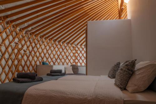 a bedroom with a large bed with a wooden ceiling at Finca Feliz Andaluz in Alora