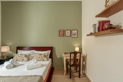 a bedroom with a bed and a table with a chair at AROI Studio in Patra