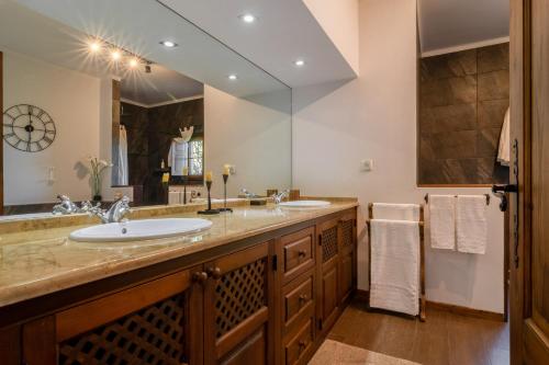 a bathroom with two sinks and a large mirror at Casa com Piscina Privada em Palmela - Jardim & Estacionamento in Palmela