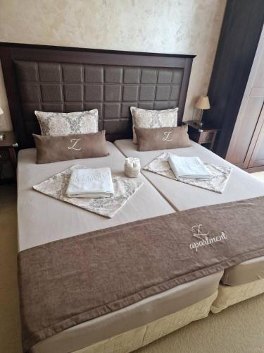 a bed with two napkins and certificates on it at Z-apartment in Sunny Beach