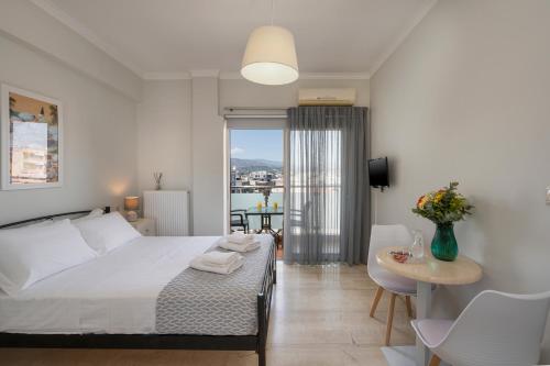 a bedroom with a bed and a table with chairs at Apartments Chania in Chania