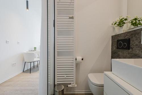 a white bathroom with a toilet and a table at Design-Studio mit Balkon - Nähe Donau in Passau