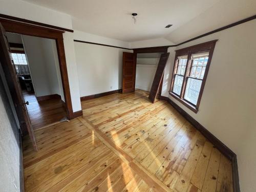 an empty living room with wooden floors and windows at Historic 1908 Wamsley House-Completing Renovation! in Hamilton
