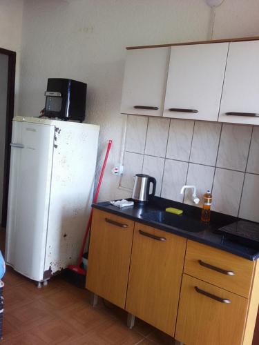 a kitchen with a white refrigerator and a sink at Paraíso chuí in Santa Vitória do Palmar