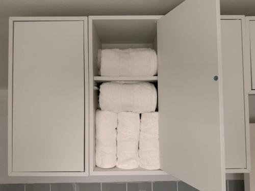 a closet filled with white towels at Charming studio apartment in the heart of Nørrebro, Copenhagen in Copenhagen