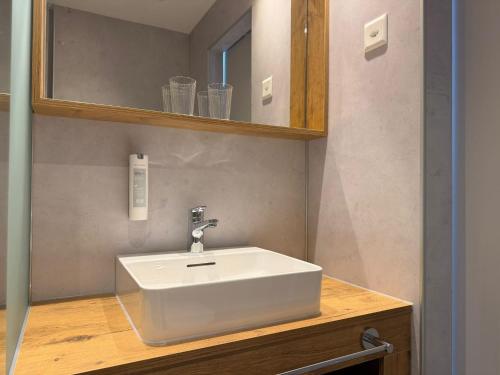 a bathroom with a white sink and a mirror at Hotel Drei Könige in Chur