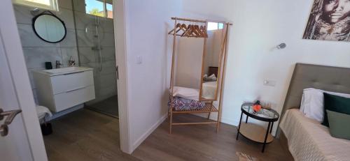 a small bathroom with a sink and a mirror at Refúgio com jacuzzi e vista mar in Estreito da Calheta