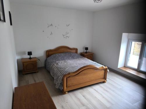 a bedroom with a bed and two tables and a window at Gîte des castors in Harricourt