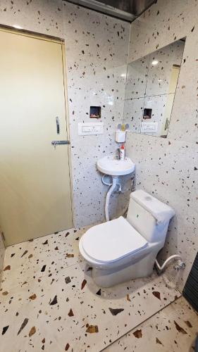 a bathroom with a toilet and a sink at Rewind by NestoraHomes in Jadgenhalli