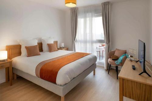 a bedroom with a bed and a desk and a television at DOMITYS LA CALYPSO in Brest