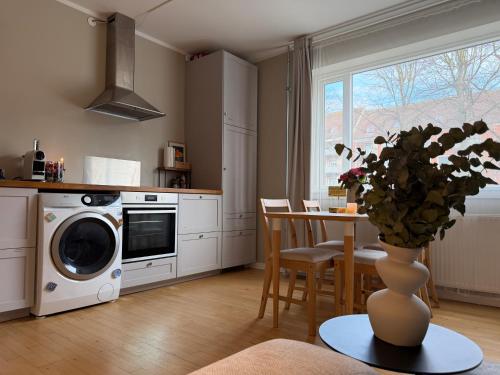 a kitchen with a vase of flowers on a table at Charming studio apartment in the heart of Nørrebro, Copenhagen in Copenhagen