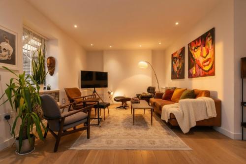 a living room with a couch and chairs and a tv at cozy 1 bedroom flat in Soho in London