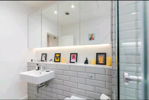 a white bathroom with a sink and a mirror at cozy 1 bedroom flat in Soho in London