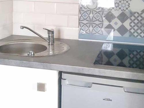 a kitchen with a sink and a counter top at Chalet avec terrasse - 6 pers. - API-1-52-2172 in Girac
