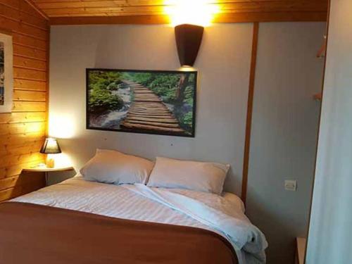 a bedroom with a bed with a picture on the wall at Chalet avec terrasse - 6 pers. - API-1-52-2172 in Girac