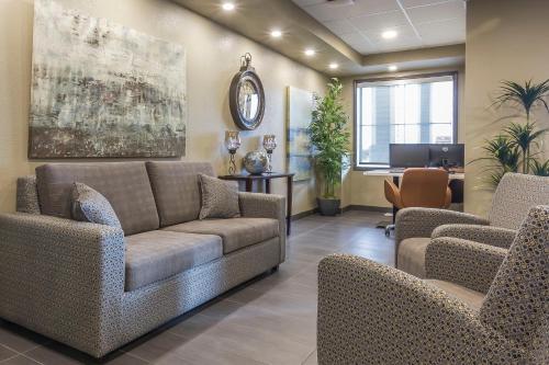 a waiting room with a couch and chairs and a desk at Quality Inn & Suites in Moose Jaw