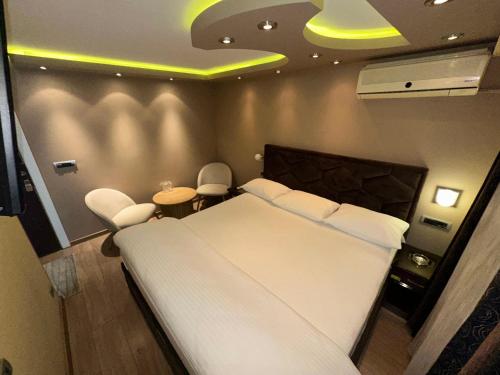 a bedroom with a large white bed and two chairs at Motel Era i Sin in Ba°evac