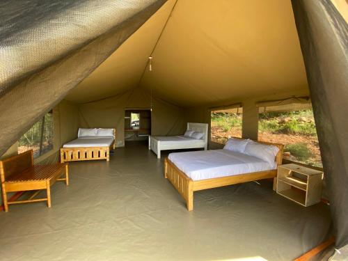 a room with two beds in a tent at Nature Lovers Camp in Sekenani