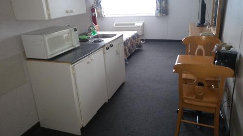 a small kitchen with a sink and a microwave at Travel Inn Hearst in Hearst