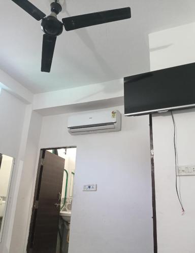 a ceiling fan in a room with a white wall at Naik Homestay in Indore