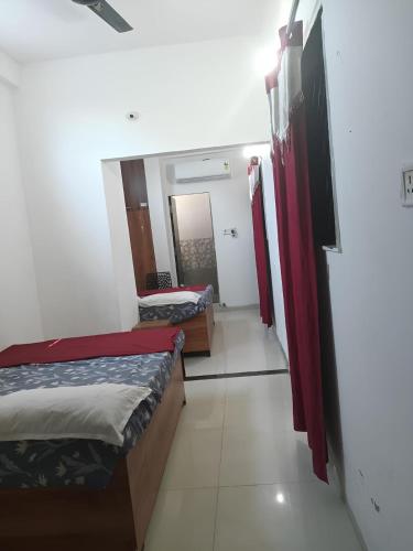 a small room with two beds and a mirror at Naik Homestay in Indore