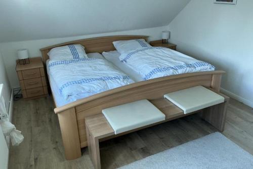 a bedroom with a wooden bed with two pillows at FewoConny in Hattstedt