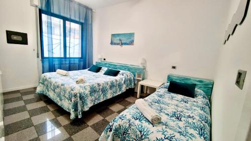a bedroom with two beds and a window at Casa Mario in Loano
